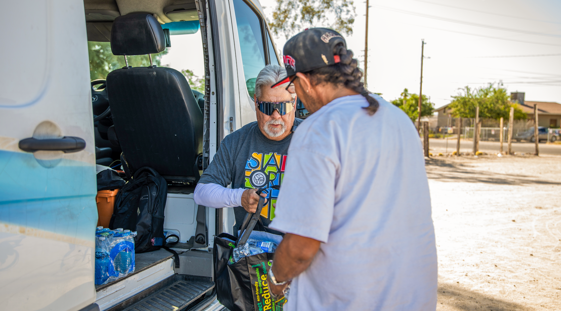A man distributing water bottles to the community through the SVdP Water Truck.