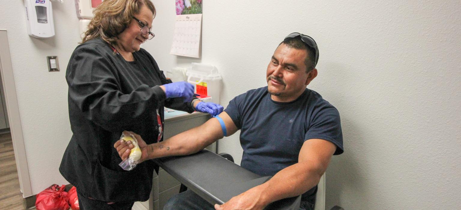 Medical Clinic Header Female doctor drawing the blood of a male patient