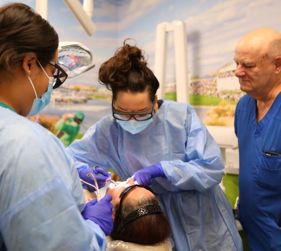 Three dentists working on a patient
