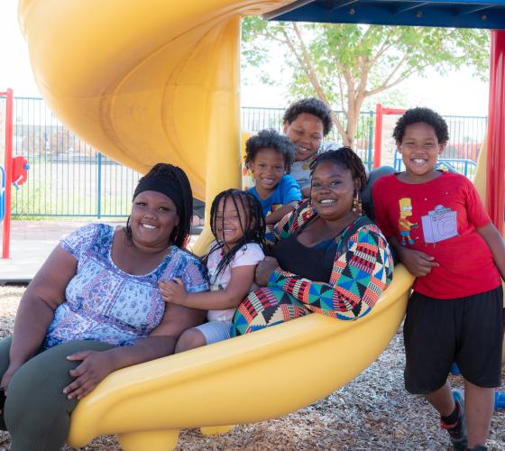 Woman and her children sitting on a playground slide