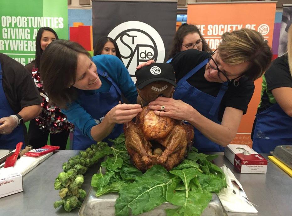 turkey-tuesday-history-4 Two women holding a cooked turkey with an SVdP hat