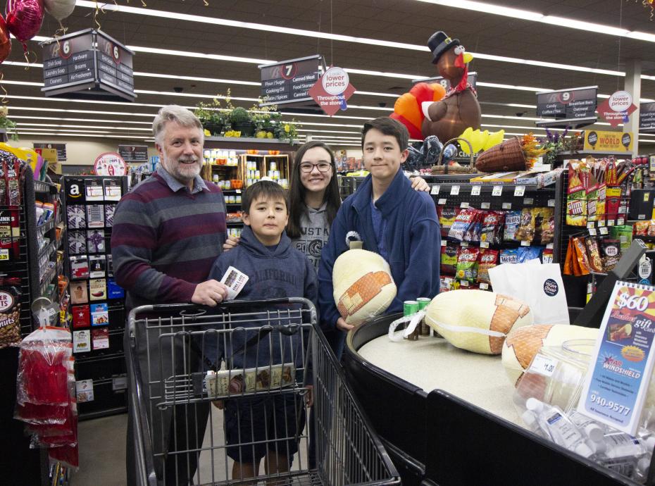 Donors posing with a turkey at the cash register of a Bashas'