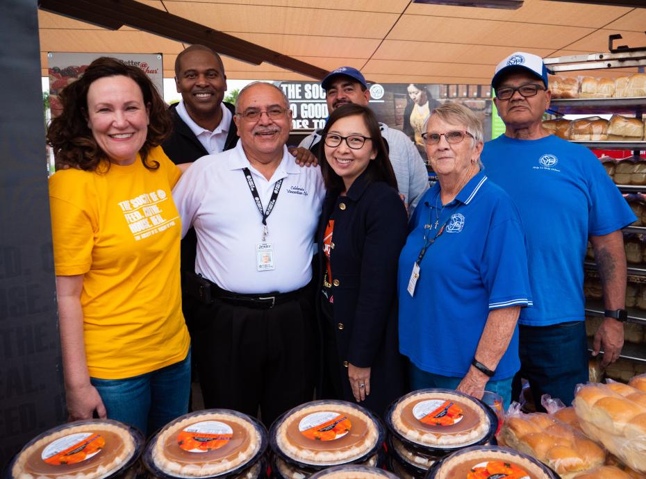 Group of people standing in front of pumpkin pies