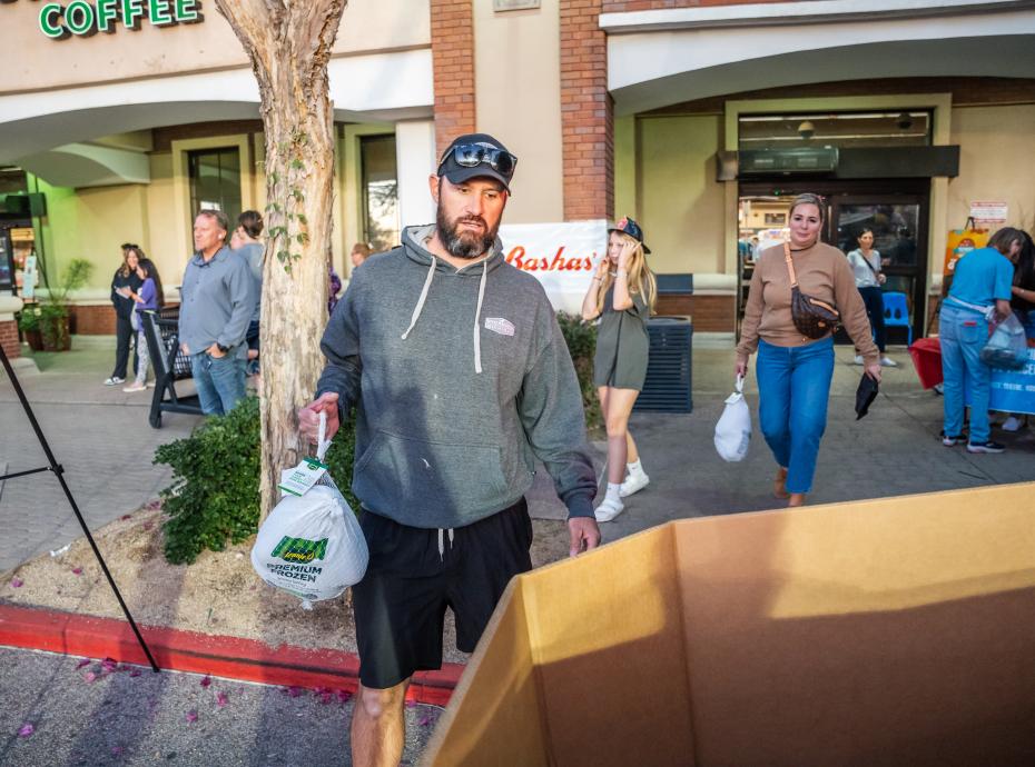 Man putting a frozen turkey into a donation bin