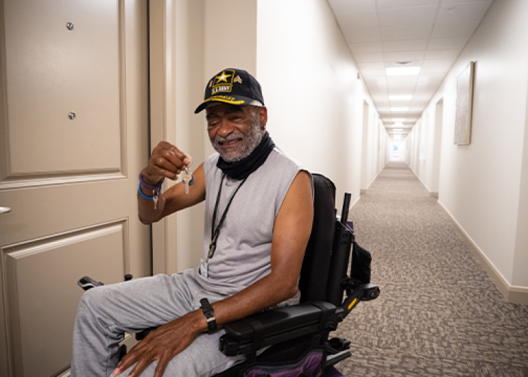 Man in long hallway showing off a set of keys