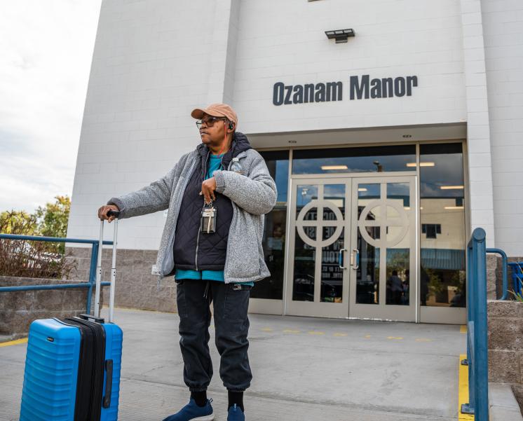 A guest stands outside of Ozanam Manor as she moves out.