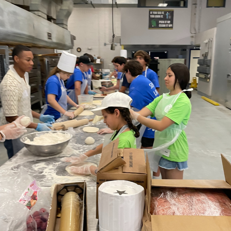 Kids making pizza in St. Vincent de Paul kitchen
