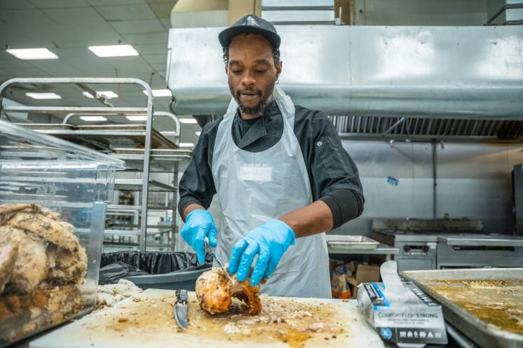 Volunteer cutting turkey for Thanksgiving