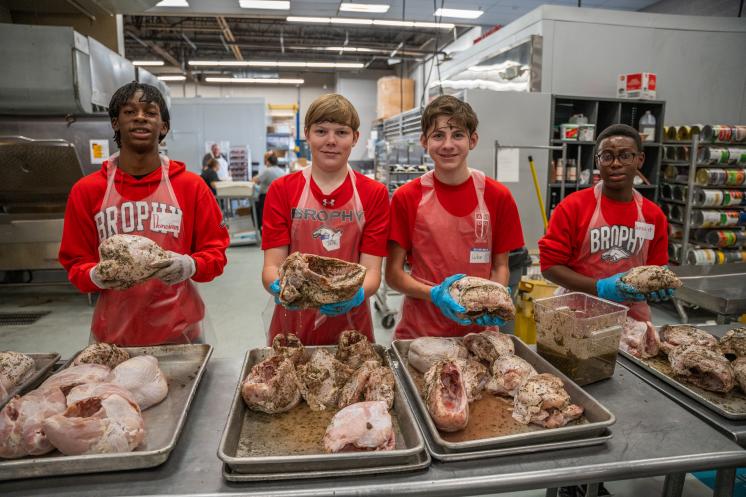 Volunteers seasoning turkeys