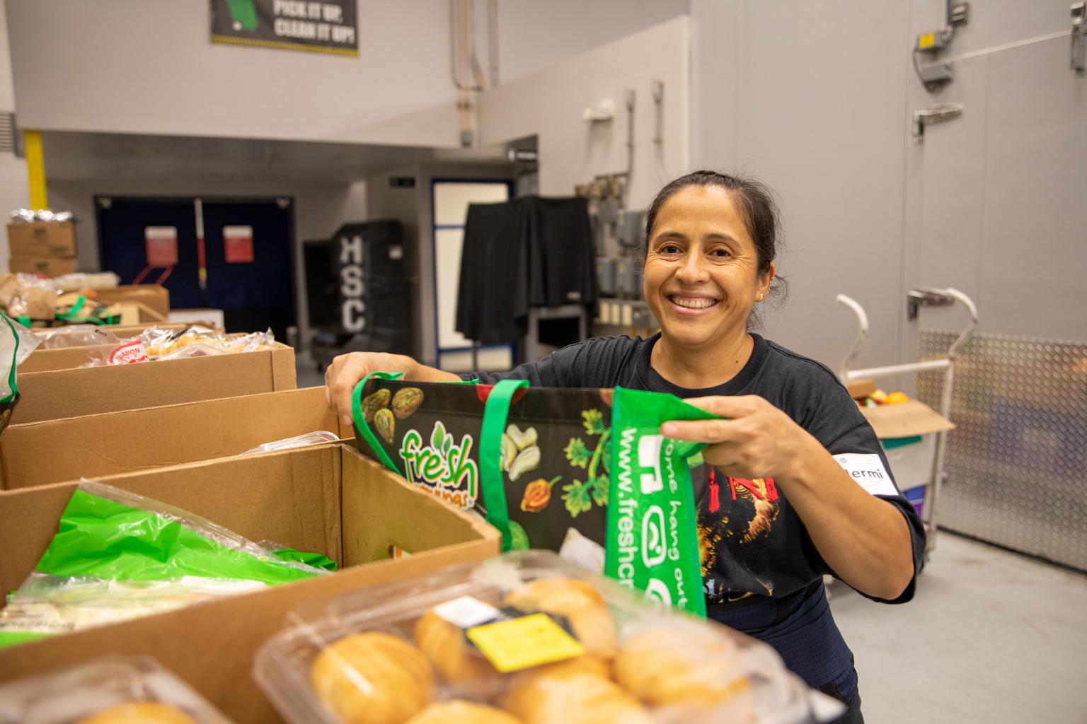 Woman loading food into a bag