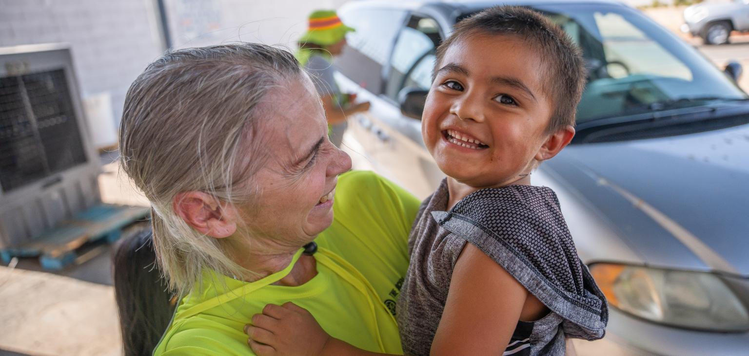 SVdP staff, Cindy Bernardo, holds a young guest.