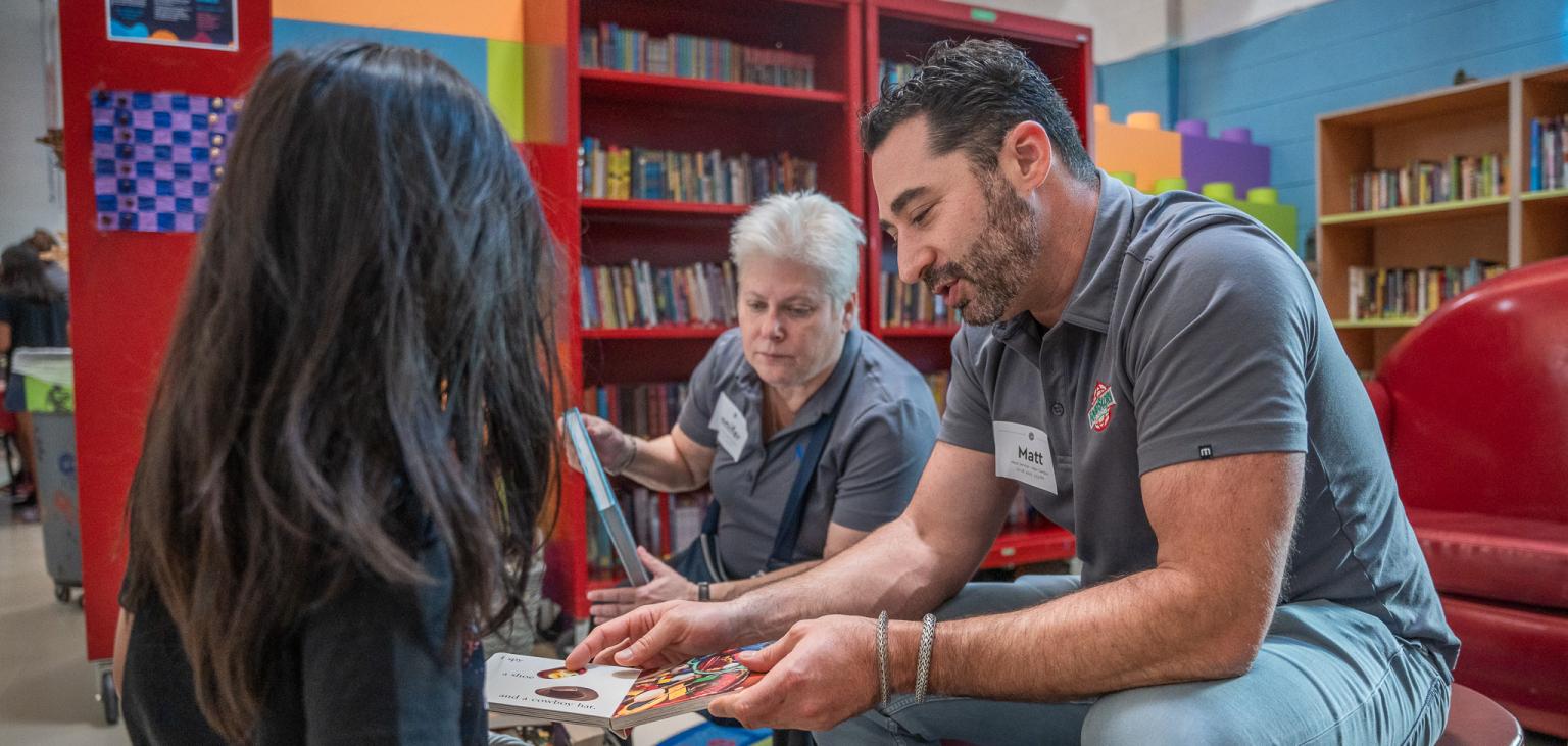 A volunteer shows a young boy a book in SVdP's Dream Center.