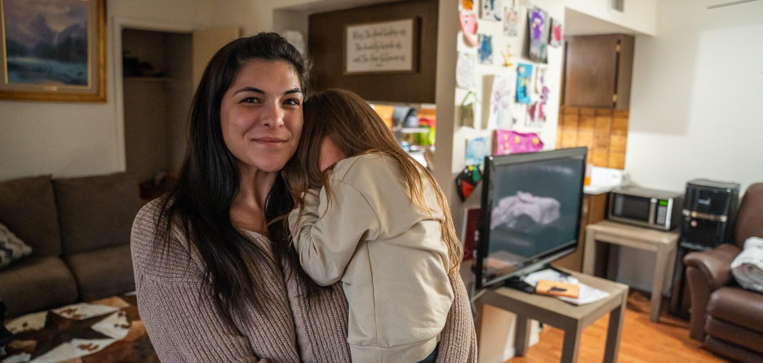 Jesse and her daughter stand in their apartment.