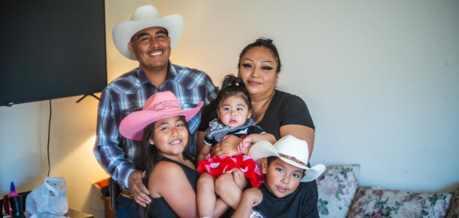 Julio Gastelum poses for a photo with his family in his new apartment.