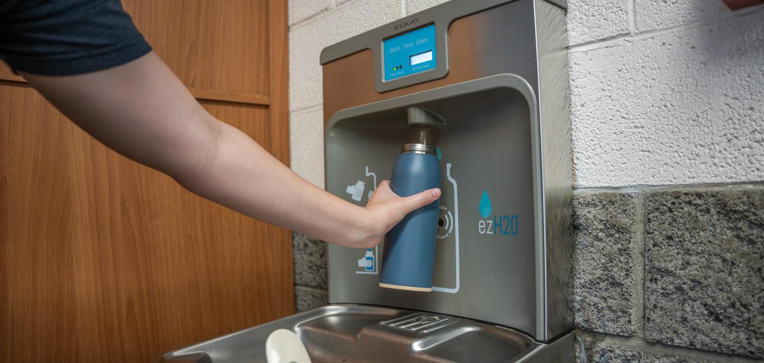 A woman fills a bottle at one of SVdP's refilling stations.
