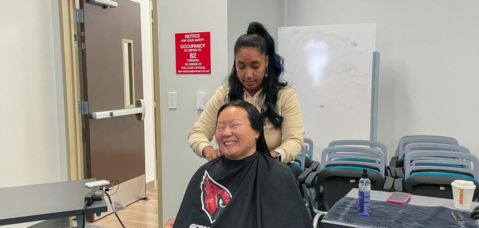 Ann Marie gets a hair cut from a volunteer from Greater Good Phoenix