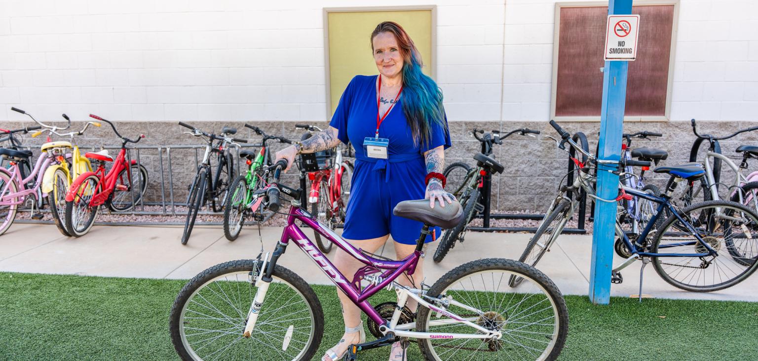 Alinda Nelson poses with her bike outside of Ozanam Manor.