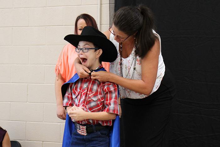 Austin Dorcey receives superhero cape and award at St. Vincent de Paul.