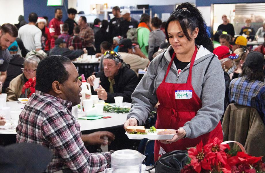 A volunteer serves a guest a meal on Christmas Day at SVdP's Phoenix Dining Room