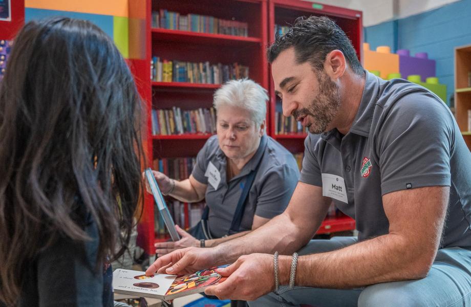 A volunteer shows a young boy a book in SVdP's Dream Center.