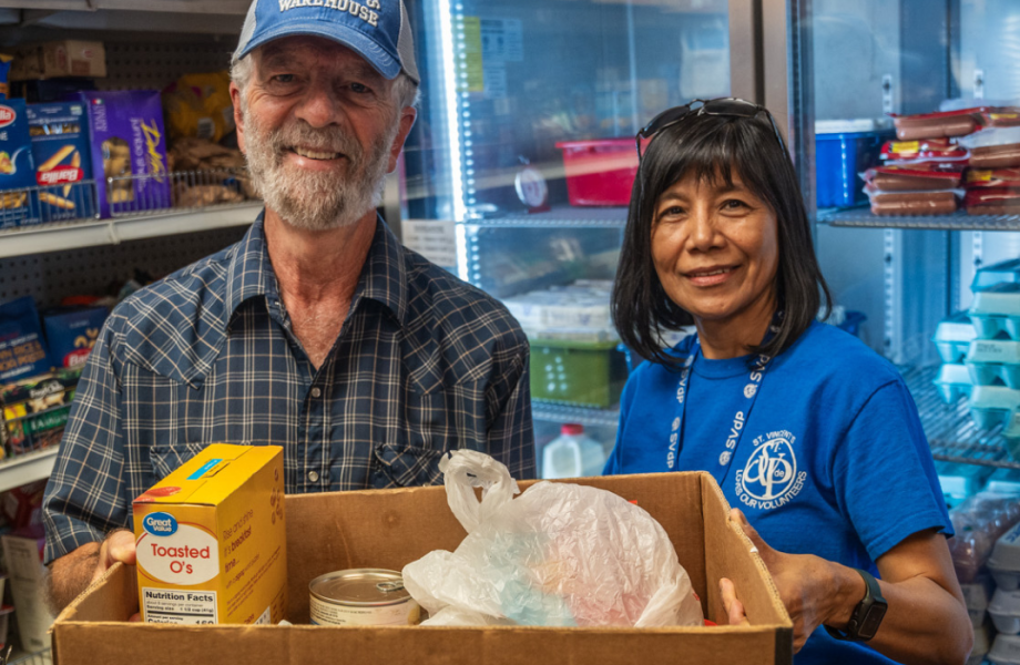 Man and woman holding a food box in a food pantry