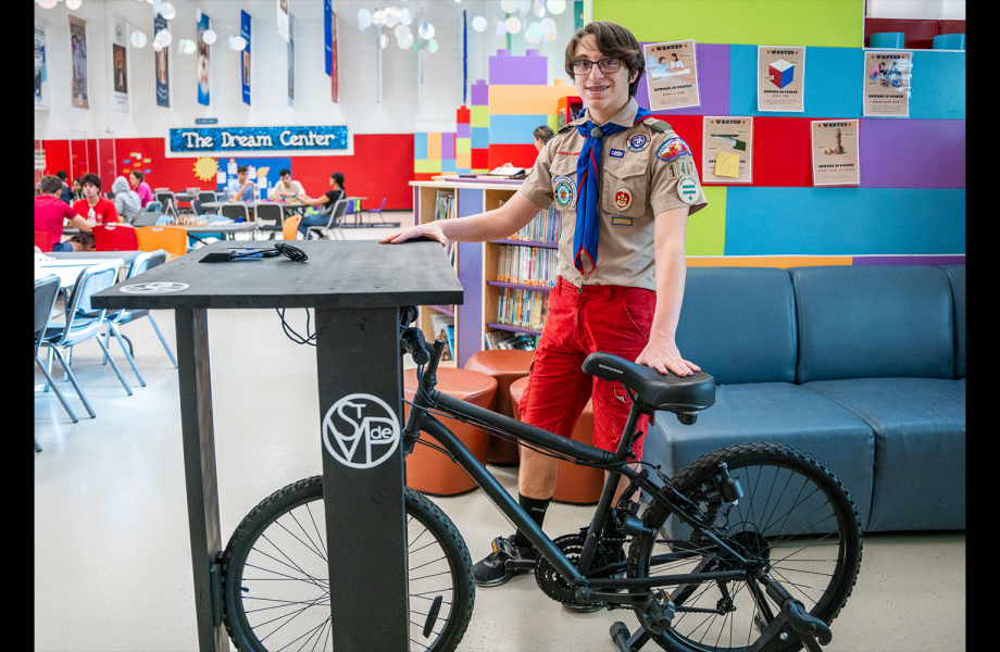 The Eagle Scout stands by the bike desk he made for SVdP.