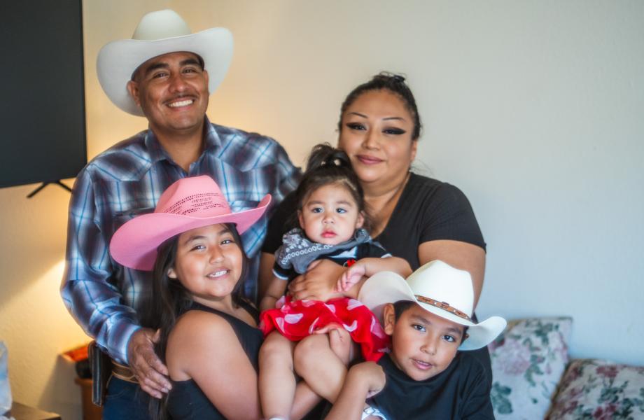 Julio Gastelum poses for a photo with his family in his new apartment.