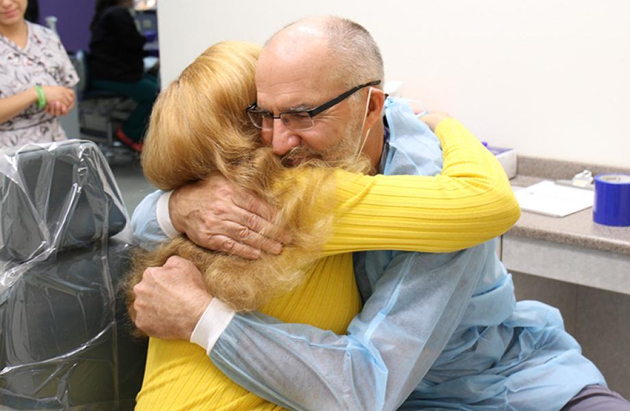 Oz Manor resident Cindy gives Dr. Rushlo a hug in SVdP's dental clinic.
