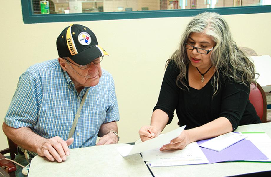 Donald Kroner fills out paperwork with SVdP staff memeber Jackie Solares.