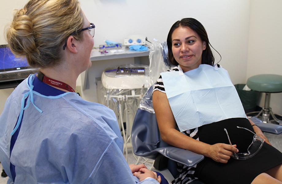 Dental clinic patient Nayeli speaks with an SVdP dental assistant.
