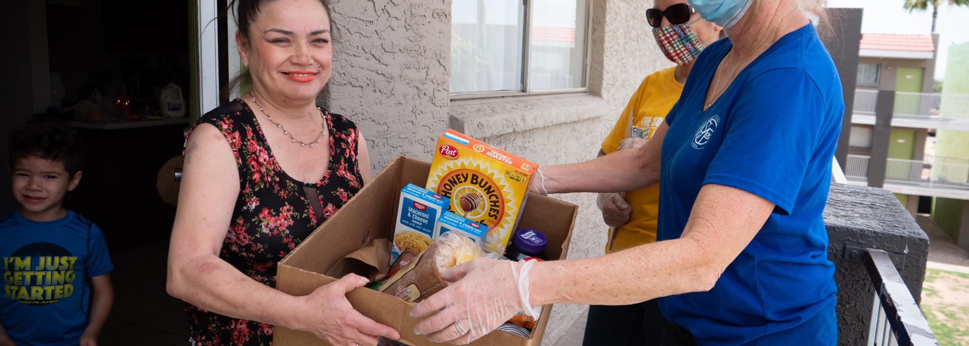 food-box-campaign-header Woman handing a food box to another woman