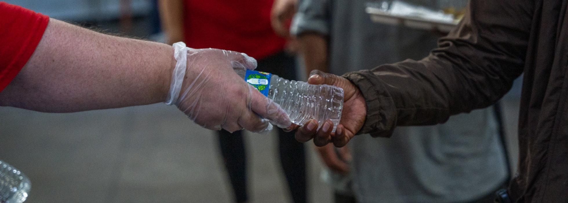 Volunteer handing a water bottle to a guest
