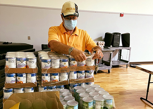 Man opening a pallet of cans