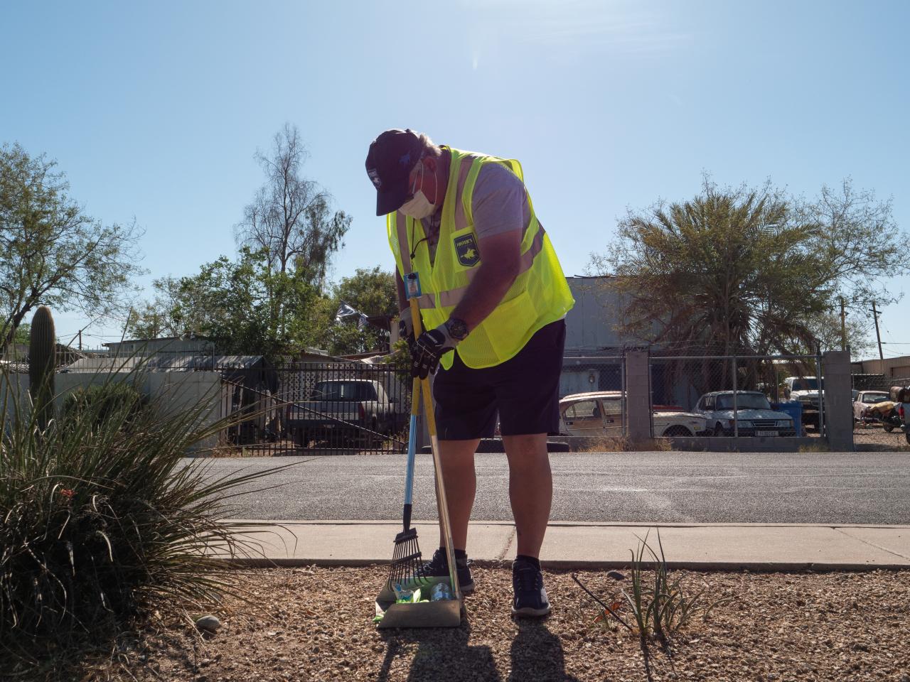 Man scooping trash onto a collector