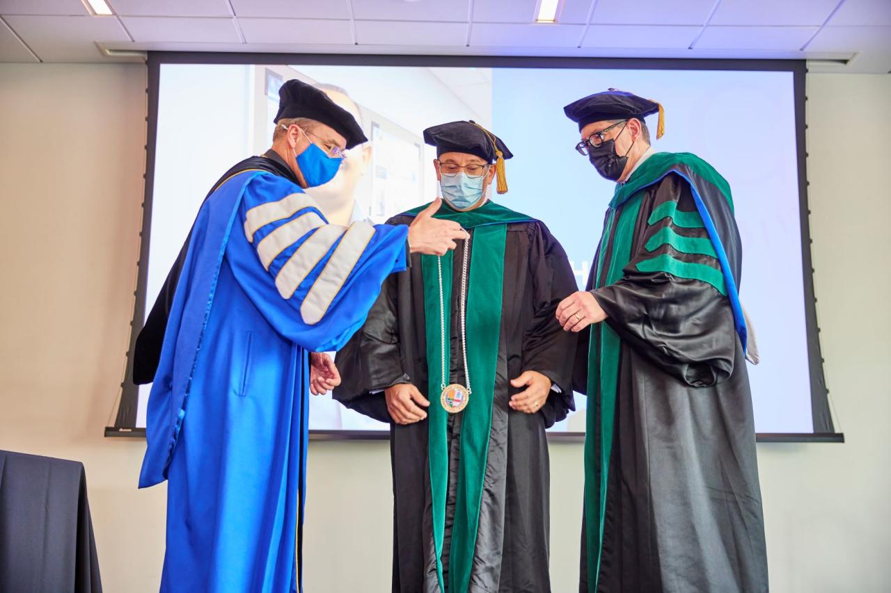 Doctors in robes presenting a medallion 