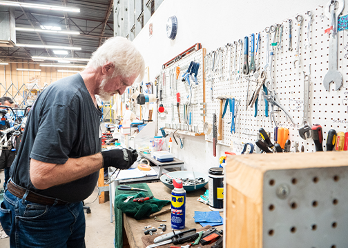 Man looking at things on a tool bench