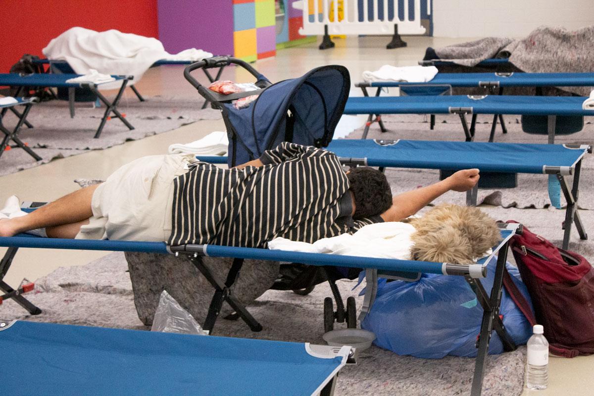 Man sleeping on cot with his back turned to the camera