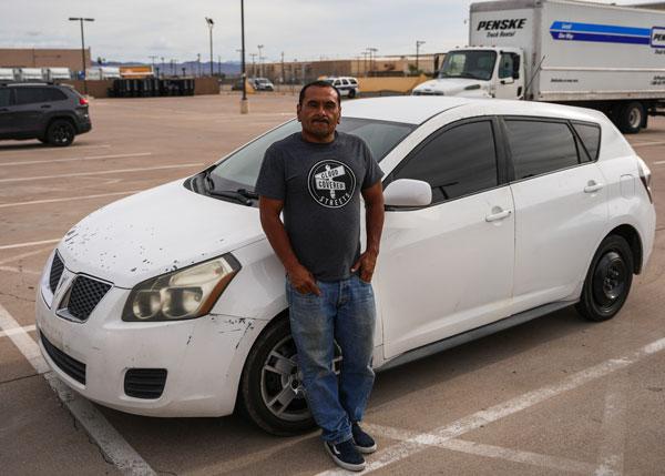 Frank leans against his car in the Washington Street Shelter parking lot.