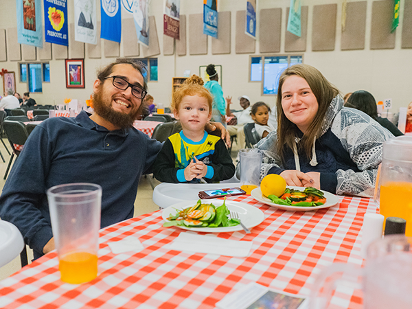 family sitting at a table eating food