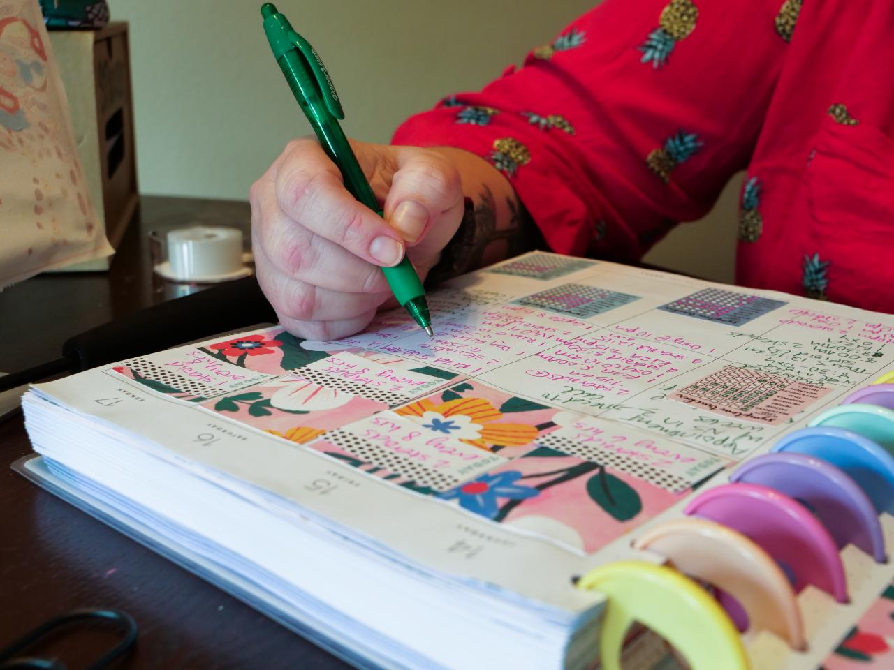 Close up view of a woman writing in a calendar