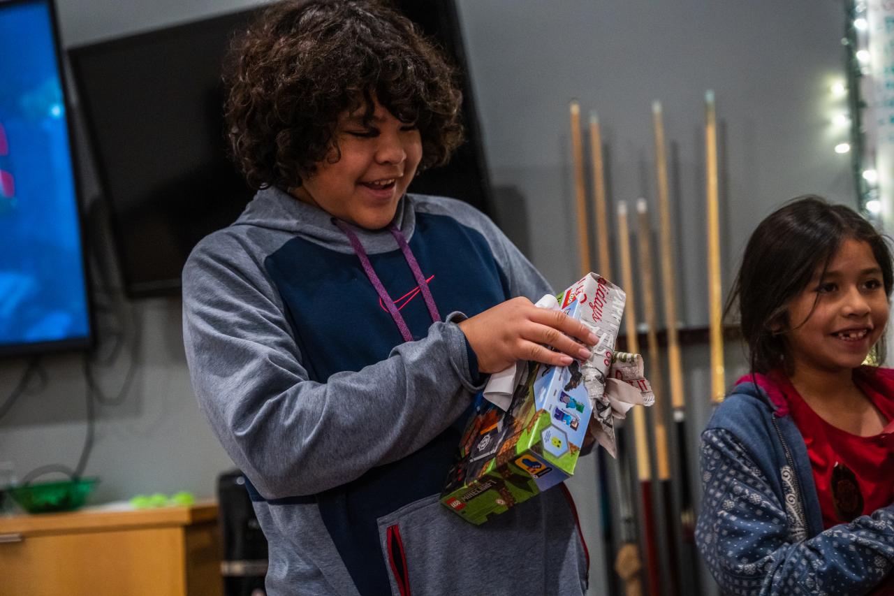 Alejandro tears open his present from the fire station.