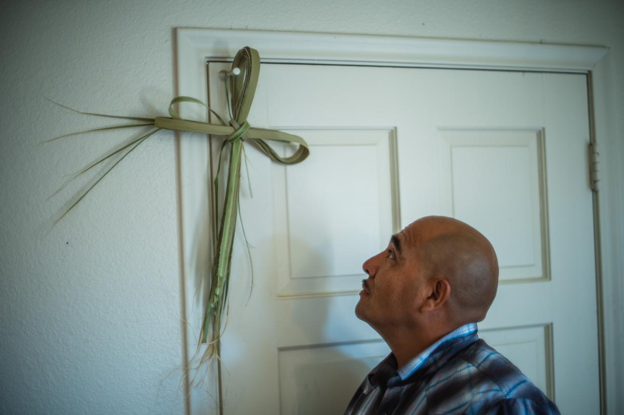 Julio looks up at a cross in his new home.