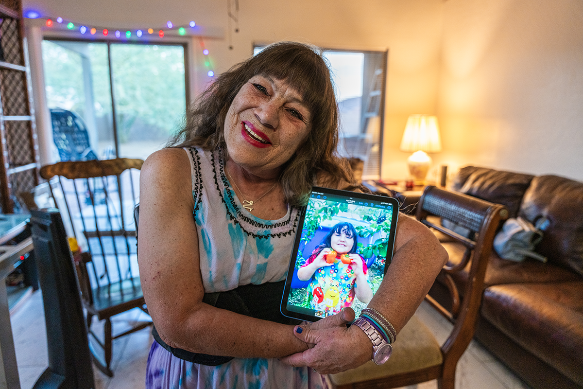 DD Brown poses with a photo of her daughter, Guinevere, from when she was a girl.