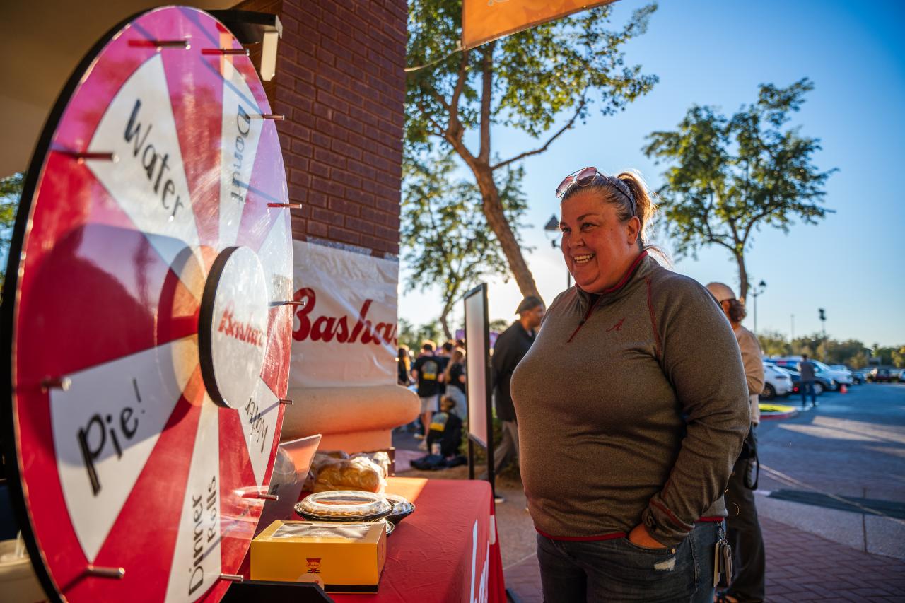 Woman spinning a wheel of chance outside a Bashas' store on Turkey Tuesday