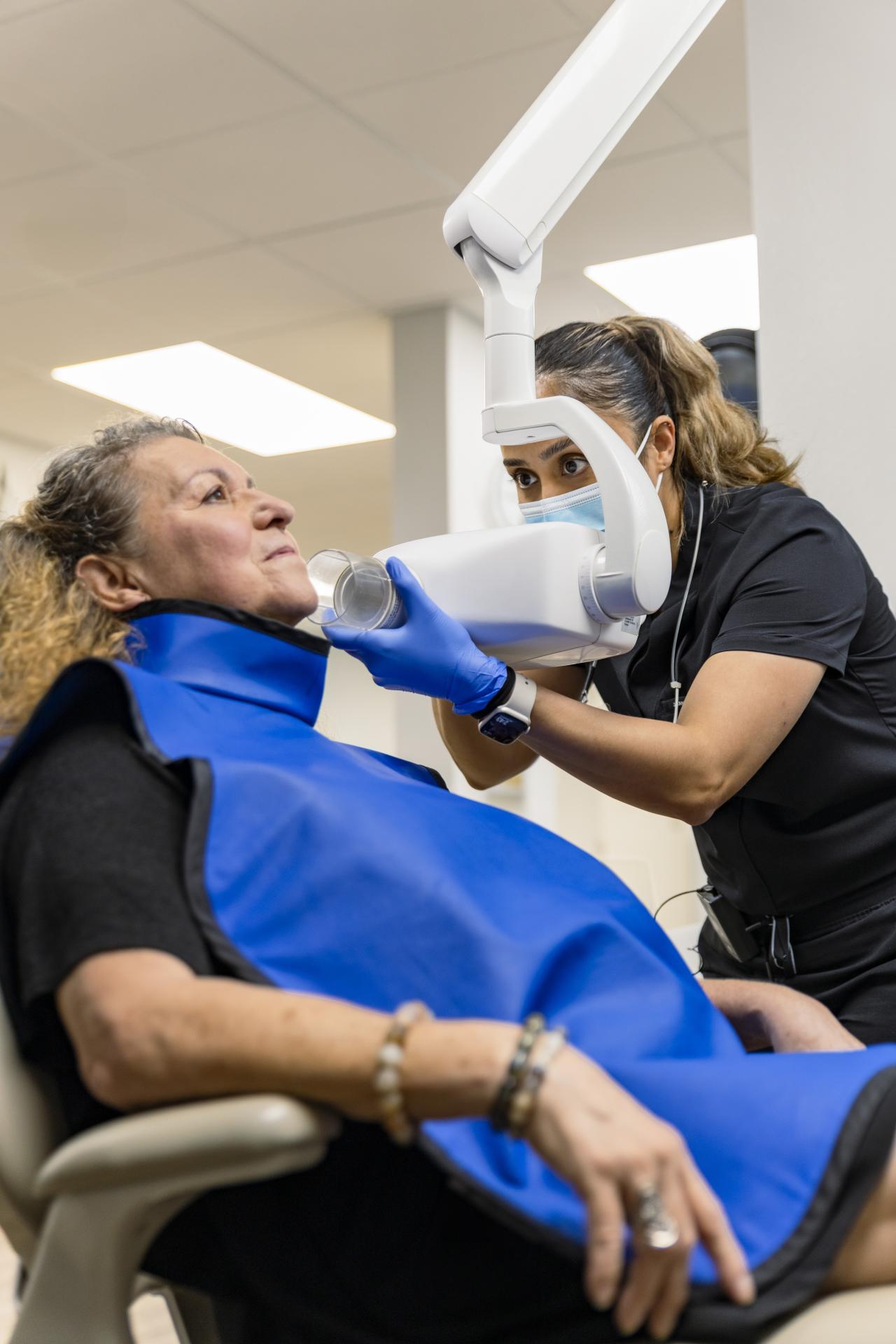 Woman sitting in a dental chair getting xrays