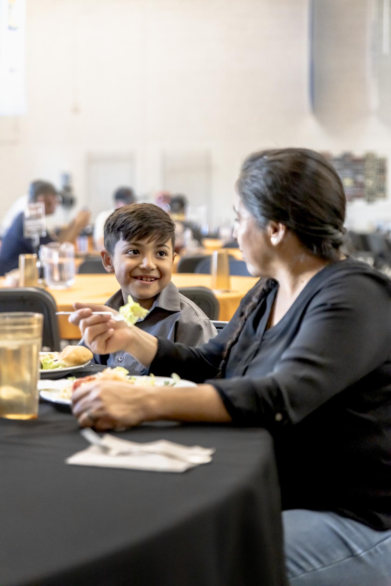 Guillermina and her son eat dinner at the SVdP family dining room