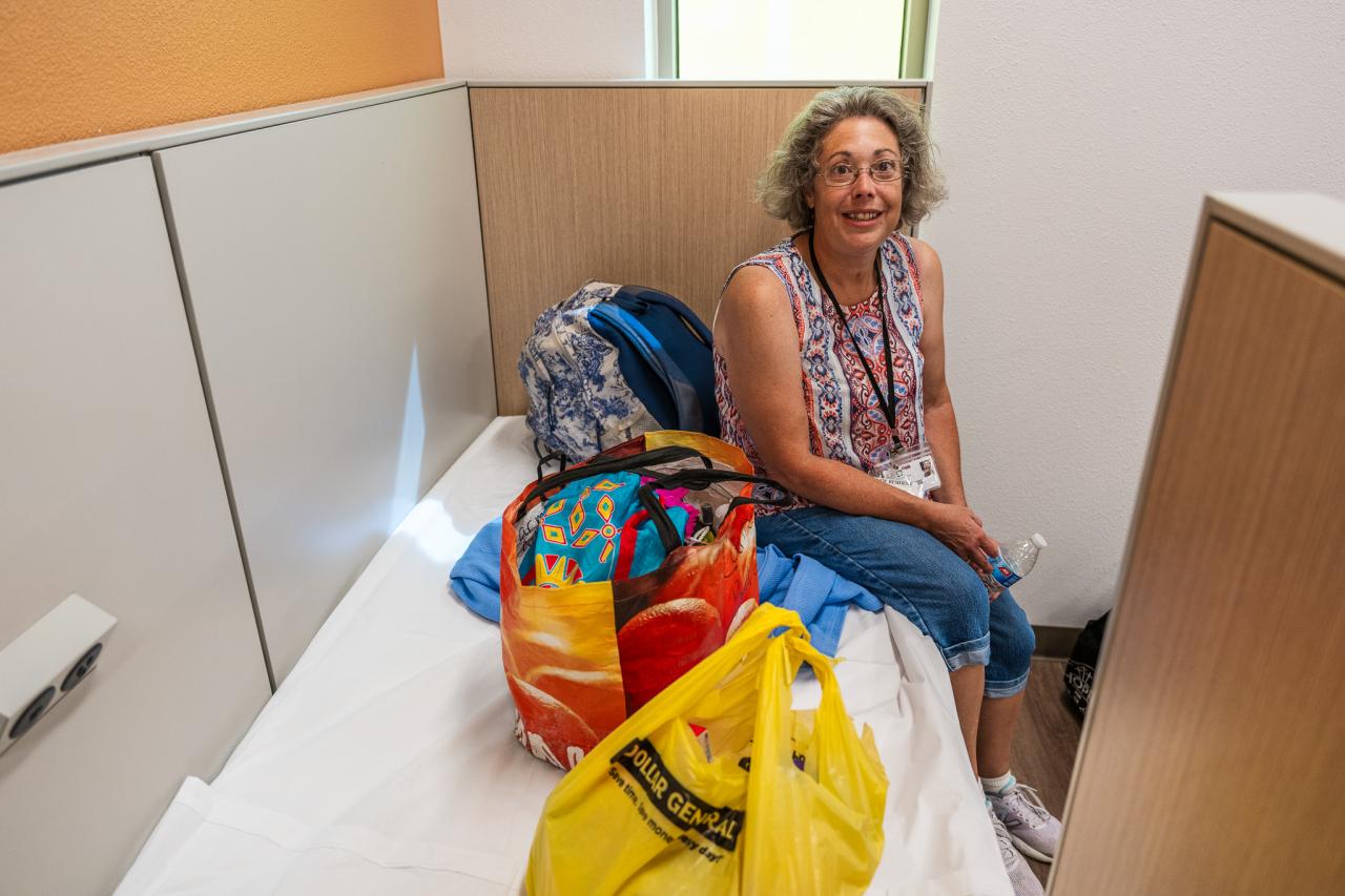 A guest in Rosalie's Place sits on her new bed.