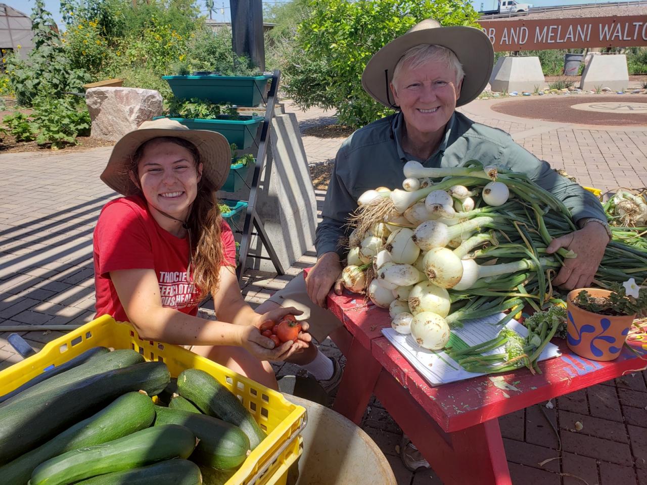 Dave Smith (at right) and farm fellow Maddie Mercer smile over the fresh produce harvested for SVdP's kitchen.