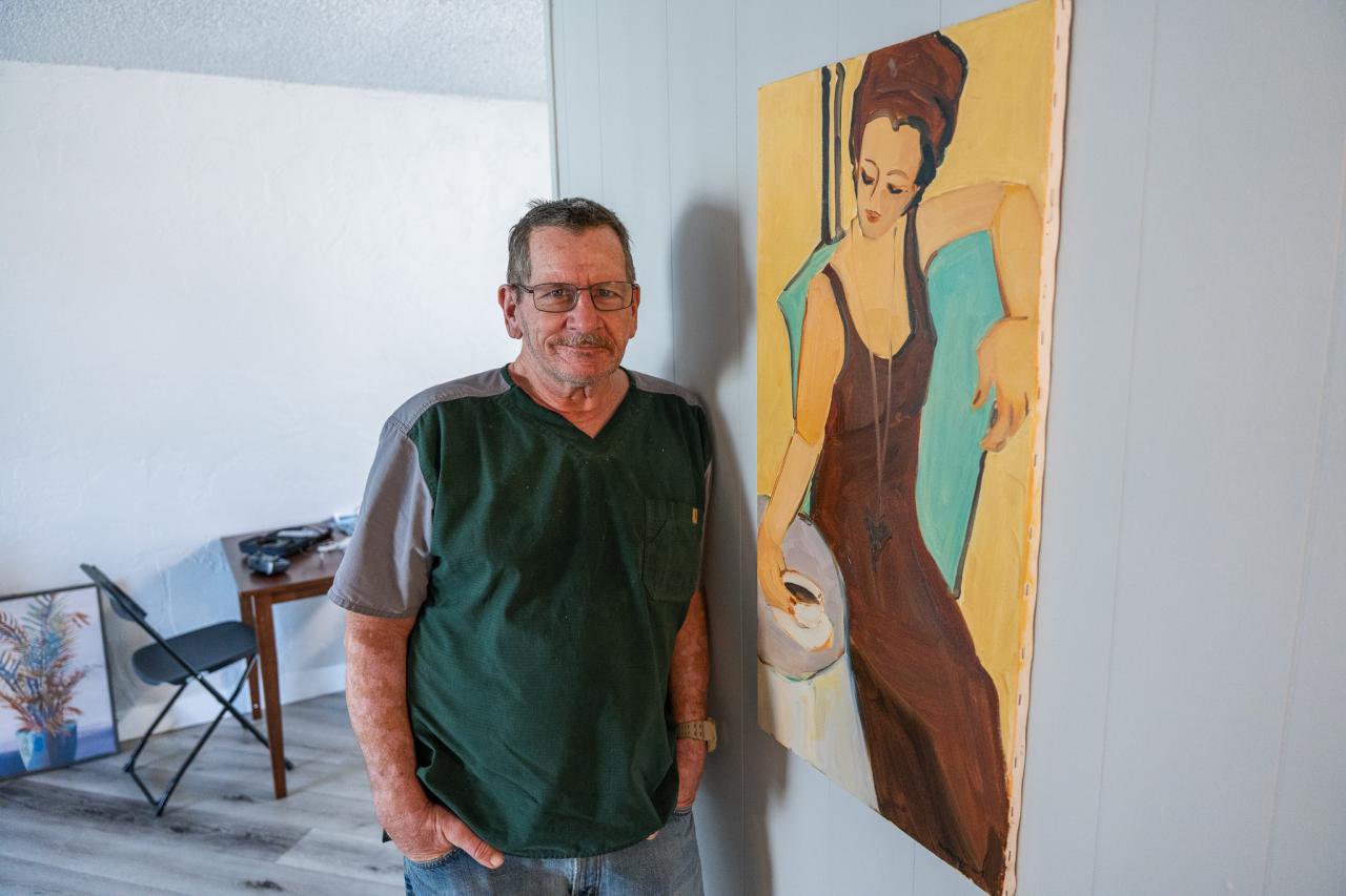 Christopher Riley stands by the photo he brought to his new home from Ozanam Manor.