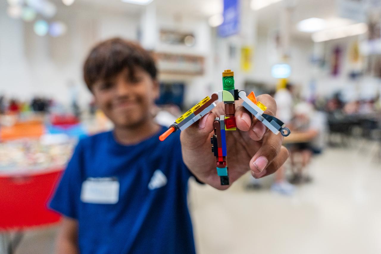 A young guest at the Dream Center shows off his Lego creation.